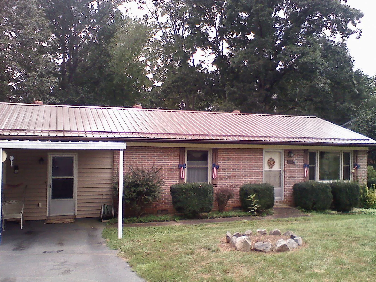 Bronze metal roof and carport on a brick ranch home — Roof Repair work by our crew in Netawaka